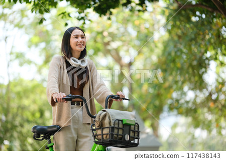 A woman is riding a bicycle with a basket on it 117438143