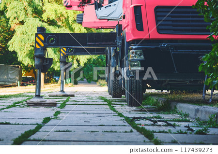 Auto crane red lifting machine stands on stops detends on the ground 117439273