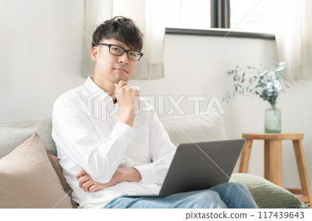 Man working in the living room, computer Man working in the living room, computer 117439643