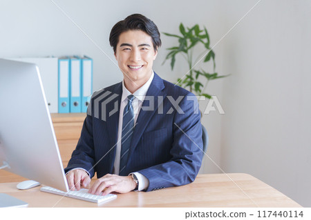 A businessman working on a desktop computer A businessman working on a desktop computer 117440114