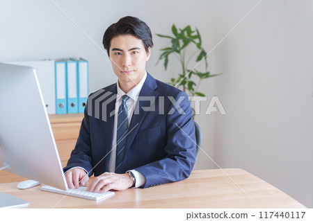 A businessman working on a desktop computer A businessman working on a desktop computer 117440117