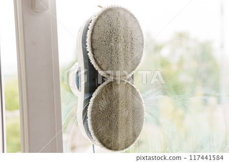 A robot window cleaner washes a window. A robot window cleaner washes a window. 117441584