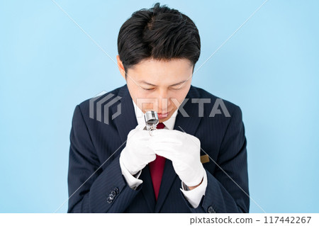 一名男子用放大鏡進行評估 117442267