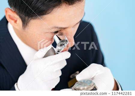 一名男子用放大鏡進行評估 117442281
