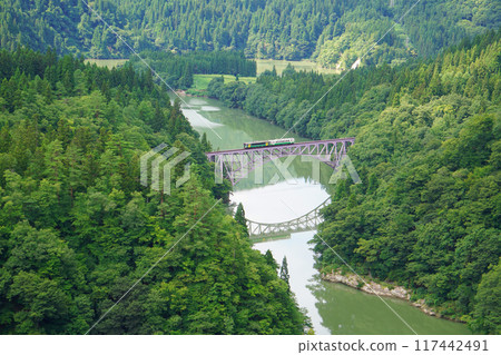 JR Tadami Line train, beautiful pond and iron bridge 117442491