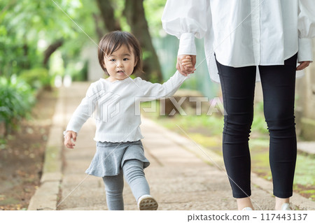Parent and child walking hand in hand 117443137