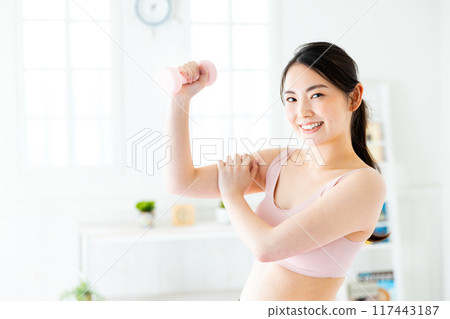 Woman doing muscle training Woman doing muscle training 117443187