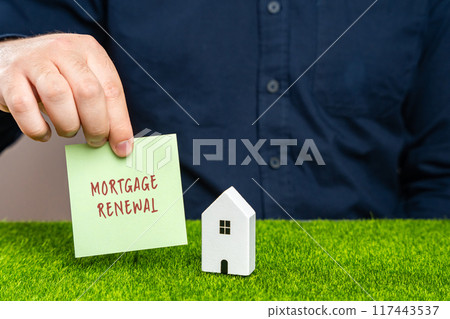 Mortgage renewal concept. Process by which a borrower extends or renegotiates the terms of their existing mortgage loan at the end of its term. Notes in the hand of a man and house. Real estate 117443537