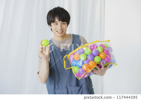 A male nursery teacher with a toy A male nursery teacher with a toy 117444395