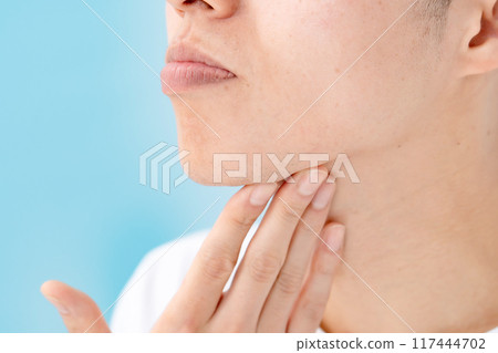 Man touching his chin, unshaved beard Man touching his chin, unshaved beard 117444702