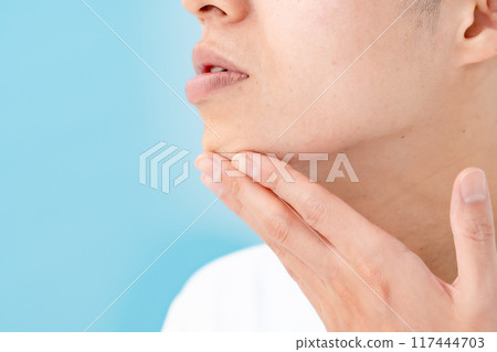 Man touching his chin, unshaved beard Man touching his chin, unshaved beard 117444703