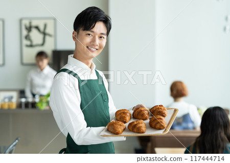 young man working in a cafe young man working in a cafe 117444714