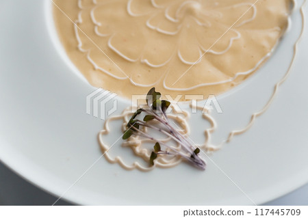 Cream soup with mushrooms on a white plate 117445709