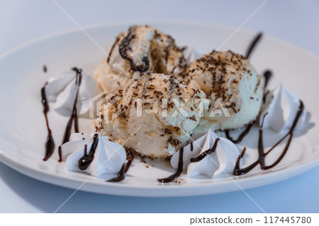 Ice cream with fruits and chocolate on a white plate Ice cream with fruits and chocolate on a white plate 117445780