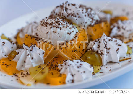 Ice cream with fruits and chocolate on a white plate Ice cream with fruits and chocolate on a white plate 117445794