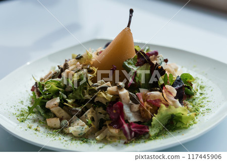Salad with several types of cheese and baked pear on a white plate Salad with several types of cheese and baked pear on a white plate 117445906