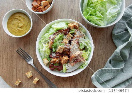 A bowl  of  Caesar salad 117446474