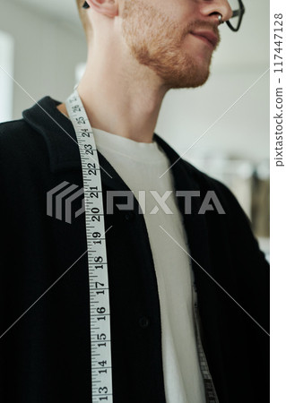 Fashion designer with measuring tape 117447128
