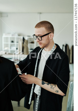 Folding long sleeve of blazer on client Folding long sleeve of blazer on client 117447136