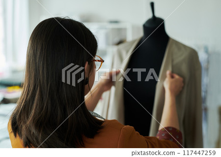 Rear view of young female tailor Rear view of young female tailor 117447259