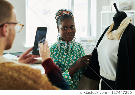 Tailor looking at smartphone camera Tailor looking at smartphone camera 117447290