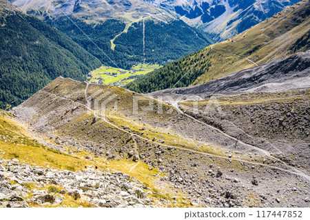 A panoramic view of the Sulden Valley in Italy, showcasing lush greenery amidst rugged mountains under a clear blue sky during summer. A panoramic view of the Sulden Valley in Italy, showcasing lush greenery amidst rugged mountains under a clear blue sky during summer. 117447852
