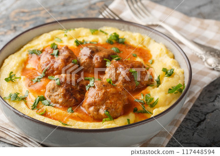 Fried meatballs with spicy sauce and corn polenta close-up in a bowl. Horizontal 117448594
