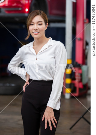 Portrait business woman standing front car at maintenance garage. 117450041