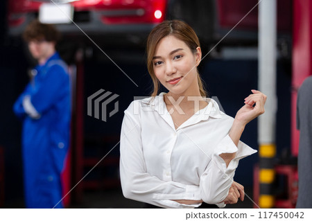 Portrait business woman standing front car at maintenance garage. 117450042
