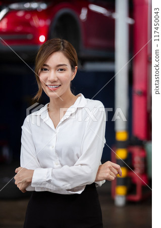 Portrait business woman standing front car at maintenance garage.  117450043
