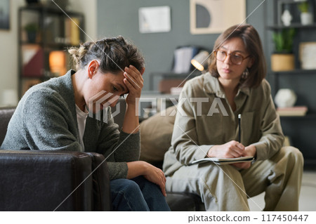 Therapist providing emotional support during counselling session, listening attentively and taking notes while patient shares struggles and emotions without any judgment or interruption Therapist providing emotional support during counselling session, listening attentively and taking notes while patient shares struggles and emotions without any judgment or interruption 117450447