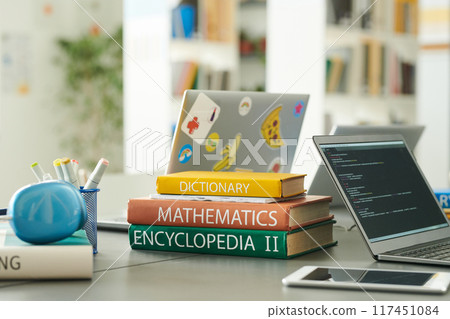 Stack of books on table in school library with laptop and code lines on screen copy space Stack of books on table in school library with laptop and code lines on screen copy space 117451084