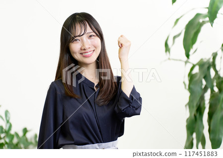 A young woman doing a small fist pump 117451883