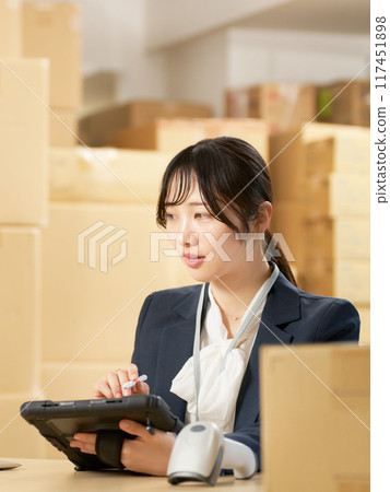 A young woman working with a tablet in a warehouse Logistics office image A young woman working with a tablet in a warehouse Logistics office image 117451898