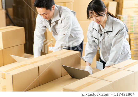 Men and women in work clothes setting up a PC Men and women in work clothes setting up a PC 117451904