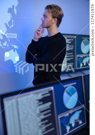 Thoughtful Cyber Security Control Center Operator Working. Multiple Screens Showing Technical Data and Alerts. Thoughtful Cyber Security Control Center Operator Working. Multiple Screens Showing Technical Data and Alerts. 117451979