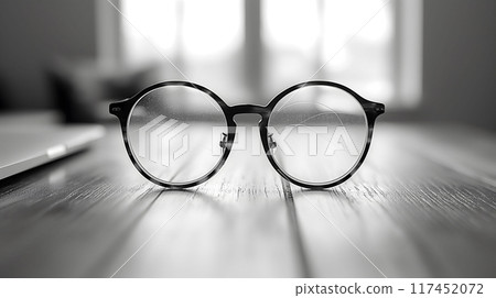 Glasses with scratched lenses on the wooden table 117452072