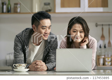 young asian couple using laptop computer together at home young asian couple using laptop computer together at home 117453895