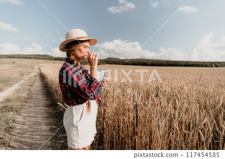 Young Woman Inspecting Wheat Field 117454585