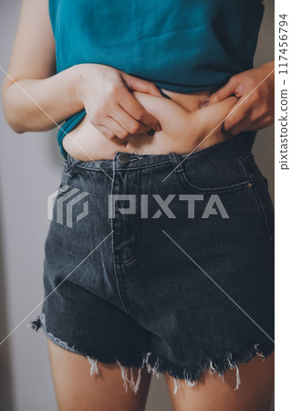 fat woman, fat belly, chubby, obese woman hand holding excessive belly fat with measure tape, woman diet lifestyle concept fat woman, fat belly, chubby, obese woman hand holding excessive belly fat with measure tape, woman diet lifestyle concept 117456794