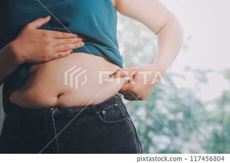 fat woman, fat belly, chubby, obese woman hand holding excessive belly fat with measure tape, woman diet lifestyle concept fat woman, fat belly, chubby, obese woman hand holding excessive belly fat with measure tape, woman diet lifestyle concept 117456804