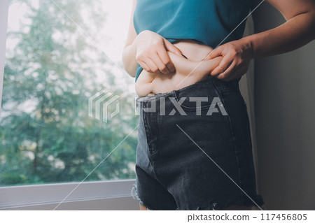 fat woman, fat belly, chubby, obese woman hand holding excessive belly fat with measure tape, woman diet lifestyle concept fat woman, fat belly, chubby, obese woman hand holding excessive belly fat with measure tape, woman diet lifestyle concept 117456805