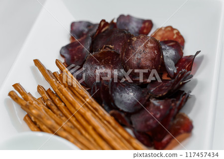 Sliced meat with sauce and breadsticks Sliced meat with sauce and breadsticks 117457434