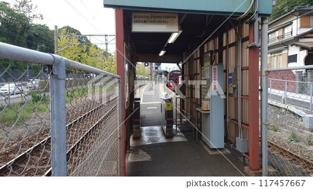 A train visible behind a small ticket barrier 117457667
