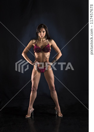 Beautiful athletic girl on a dark background Beautiful athletic girl on a dark background 117457678