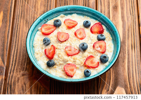Homemade breakfast . Oatmeal with milk and berries . Top view 117457913