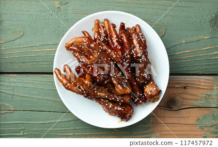 Caramelized korean or Chinese chicken foots ( paws ) with sesame . Top view 117457972