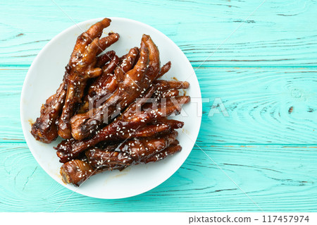 Caramelized korean or Chinese chicken foots ( paws ) with sesame . Top view Caramelized korean or Chinese chicken foots ( paws ) with sesame . Top view 117457974