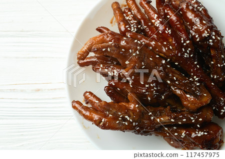 Caramelized korean or Chinese chicken foots ( paws ) with sesame . Top view 117457975