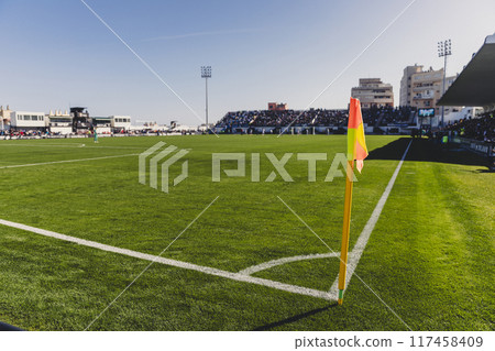 Closeup red flag in a football ground corner with bright blue sky 117458409